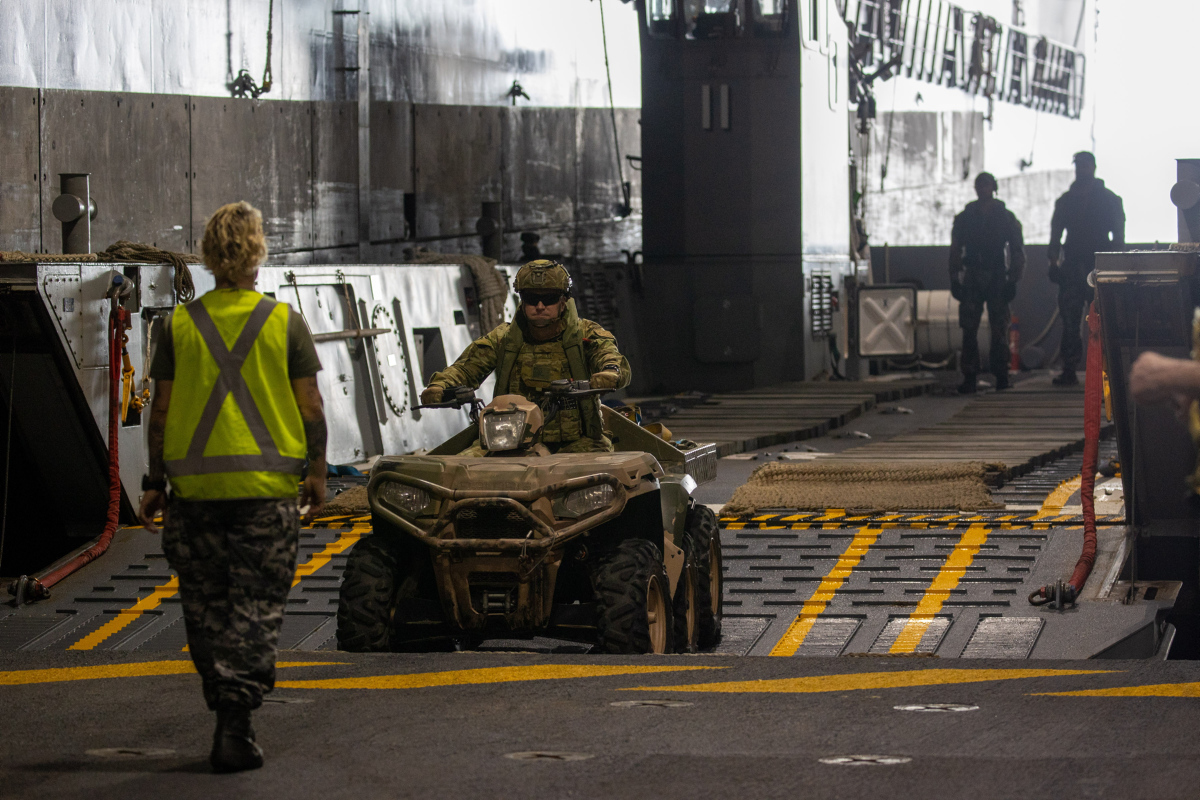 Australian Army soldier Warrant Officer Class 2 Iain MacDonald, 1st Battalion, the Royal Australian Regiment, reverses an All Terrain Vehicle onto one of HMAS Adelaide's Lighter Landing Craft during Exercise Sea Explorer 2022.