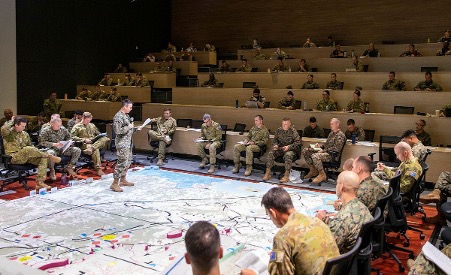 Officers around a large mud map on the ground.