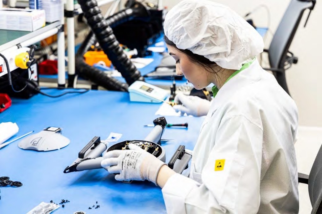 Female at laboratory bench working on a drone.