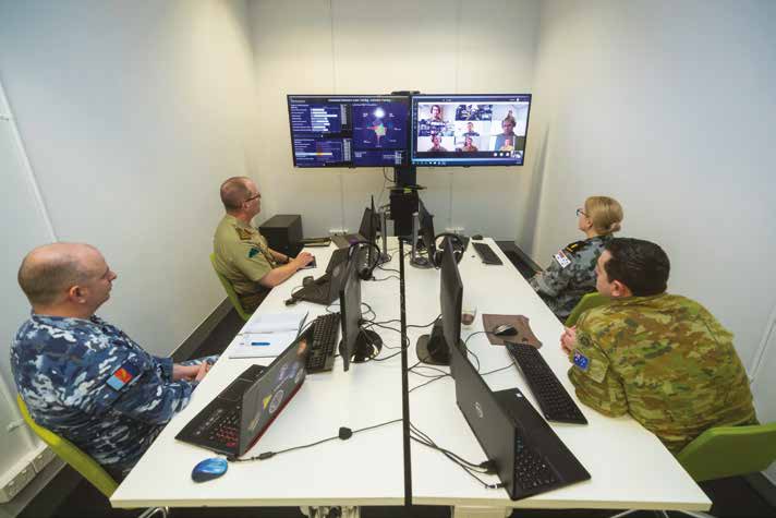 Officers sitting in a room conducting a virtual briefing.