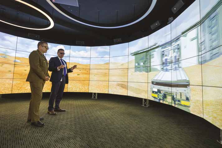 An Army Officer show a training simulator to a civilian.