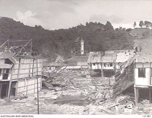 A bomb-damaged residential area. The railway station and clock tower are in the middle distance.