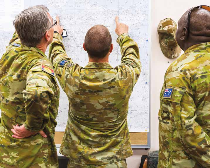 Officers looking over a map on the wall.