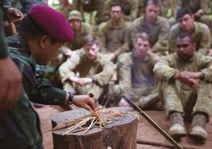 A Malaysian Officer showing field techniques to Australian soldiers.