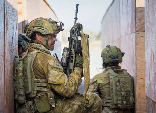 Soldiers prepare to conduct a live-fire assault during an urban combat training exercise.