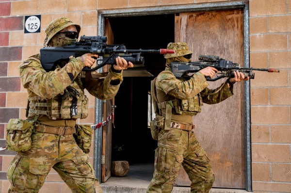 An Australian Army soldier and Army Reserve soldier conduct urban close combat clearances, during an integration activity at Townsville Field Training Area in Queensland, during Exercise Talisman Sabre 2021.