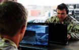 Corporal Silvester (facing) and Signalman Rowe - with wireless networked laptops - play Call of Duty during some downtime at the end of another day at their base in Tarin Kowt, Afghanistan.