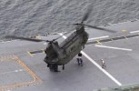 A CH-47D Chinook about to hook up an external load on board a Navy LHD.