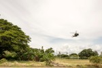 An Australian Defence Force MRH-90 helicopter flies over a traditional building in Honiara on Guadalcanal in the Solomon Islands.