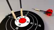 Two darts in a dartboard and one beside the dartboard