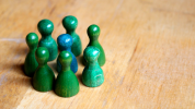 Green standing pegs surrounding a blue standing peg