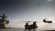 Chinook helicopter on flight deck of RAN LHD with flying Chinook in background