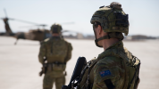Soldiers walking towards helicopter, backs to the camera.