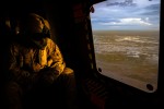 Australian Army Aircrewman, Corporal Stewart Eddleston looks out over floodwaters in the Kimberley region of Western Australia from an MRH-90 Taipan helicopter.