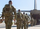 Soldiers walking away from view towards aircraft rear ramp