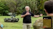 Mr Shawn Tansley from 'Built In Australia 5' explains the uses of the Warfighter Unmanned Ground Vehicle in a combat role during the dismounted combat program, robotics and autonomous systems display at the 1st Battalion, The Royal Australian Regiment, Lavarack Barracks, Townsville.