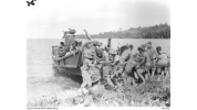 Biamu, Oro Bay, New Guinea. 1942-11-11. Gunners of the 2/5th Field Regiment unloading their 25 pounder gun at Biamu Village. This gun is being unloaded from a Japanese barge which was captured during the abortive landing attempt at Milne Bay during 1942-08/07. Source: Australian War Memorial