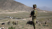 Soldier looking down a hill with squad in background
