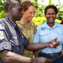 Australian Army Sergeant Jasmine Johnston reads over Operation RENDER SAFE 14 safety messages with Bougainville Police Officers Simon Sireung and his wife Lynn, during a community engagement activity in the Torokina District.