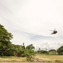 An Australian Defence Force MRH-90 helicopter flies over a traditional building in Honiara on Guadalcanal in the Solomon Islands.