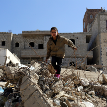 Child standing on city rubble.