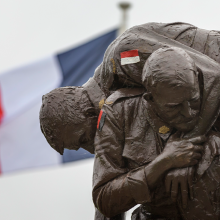 French Cobbers statue in foreground with French National flag flying to left in background