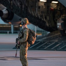 A Royal Australian Air Force Airfield Defence Guard from No. 2 Security Forces Squadron secures Wellcamp Airport, Toowoomba as Australian Army soldiers from the 8th/9th Battalion, The Royal Australian Regiment, dismount a Royal Australian Air Force C-17A Globemaster apart of Exercise Ram Stallion.
