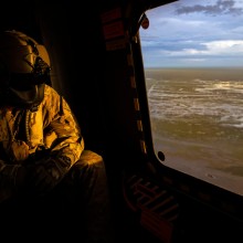 Australian Army Aircrewman, Corporal Stewart Eddleston looks out over floodwaters in the Kimberley region of Western Australia from an MRH-90 Taipan helicopter.