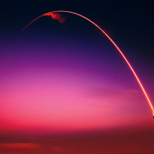 Rocket with trail and red sunset background