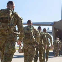 Soldiers walking away from view towards aircraft rear ramp