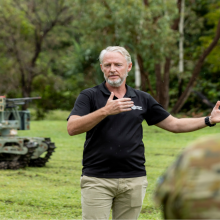 Mr Shawn Tansley from 'Built In Australia 5' explains the uses of the Warfighter Unmanned Ground Vehicle in a combat role during the dismounted combat program, robotics and autonomous systems display at the 1st Battalion, The Royal Australian Regiment, Lavarack Barracks, Townsville.