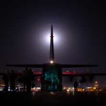 Australian citizens and visa holders form a line to board the Royal Australian Air Force C-130J Hercules as Australian Army Infantry personnel provide security at Hamid Karzai International Airport.