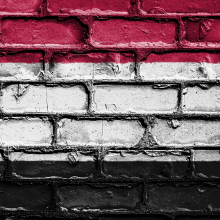 Brick wall painted in red, white and black horizontal stripes