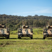 Three Australian Army M113AS4 Armoured Personal Carriers enhanced as Optionally Crewed Combat Vehicles (OCCV) stand ready to demonstrate their potential at Puckapunyal Army Base.
