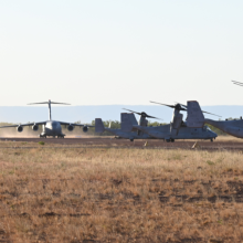 Royal Australian Air Force Boeing C-17A Globemaster III prepares for takeoff at Nackaroo Airfield, Bradshaw Field Training Area near three United States Marine Corps MV-22B tilt rotor aircraft as part of Exercise Loobye.