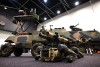 A quadrupedal uncrewed vehicle, colloquially known as a ‘robot dog’, fitted with mock 66mm anti-armour weapons sits in front of a GUS 4 (Ground Unmanned System) surveillance system at the Chief of Army Symposium 2023 in Perth.